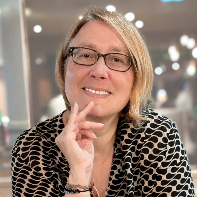Ivonne Bellen, neue Projetleiterin, trägt eine Brille, hat mittellanges blondes Haar und sieht lächelnd nach vorne. 
