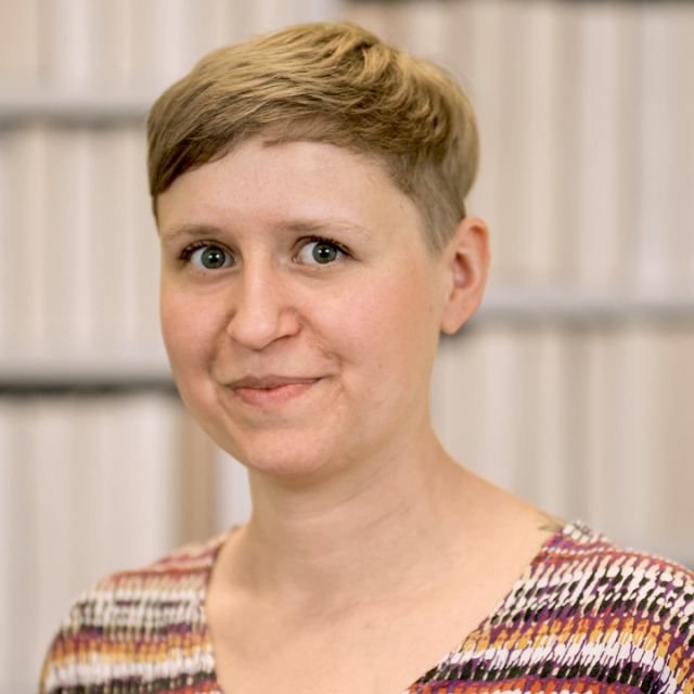 Porträt Lea Helmrich. Sie hat kurzes, hellbraunes Haar, von den Schultern aufwärts zu sehen und trägt ein bunt gemustertes Oberteil. Porträt Lea Helmrich. Sie hat kurzes, hellbraunes Haar, von den Schultern aufwärts zu sehen und trägt ein bunt gemustertes Oberteil.
