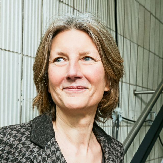 Porträt von Prof. Dr. Mathilde Niehaus. Sie hat schulterlanges Haar steht vor einer gefliesten Wand. Sie trägt eine gemusterte Jacke. Porträt von Prof. Dr. Mathilde Niehaus. Sie hat schulterlanges Haar steht vor einer gefliesten Wand. Sie trägt eine gemusterte Jacke.
